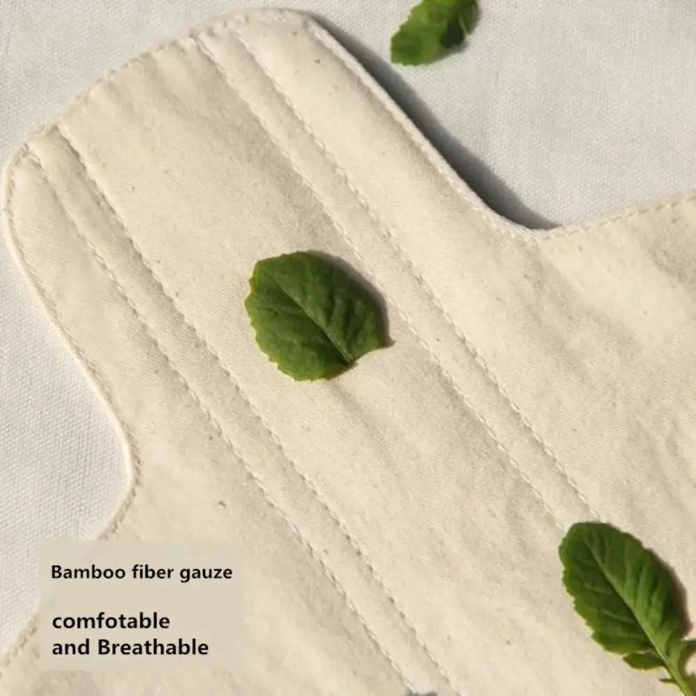 A close up of the The Reusable Sanitary Pad, with tiny leaves resting on and around the pad.